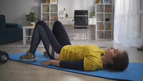 Körperliche-Bewegung-Zu-Hause-Junge-Frau-Trainiert-Allein-Im-Wohnzimmer-Am-Morgen-Auf-Dem-Boden-Liegend-Und-Hüften-Heben,-Bauch--Und-Rückenmuskulatur-Anspannen